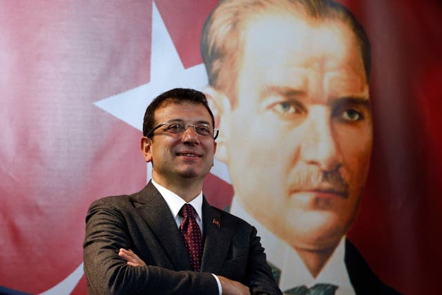 Backdropped by a poster of modern Turkey's founder Mustafa Kemal Ataturk, right, Ekrem Imamoglu, the opposition poses for The Associated Press