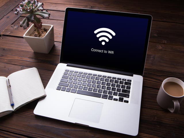 View of wi-fi connection on the laptop / computer screen with office equipment on wooden desk background