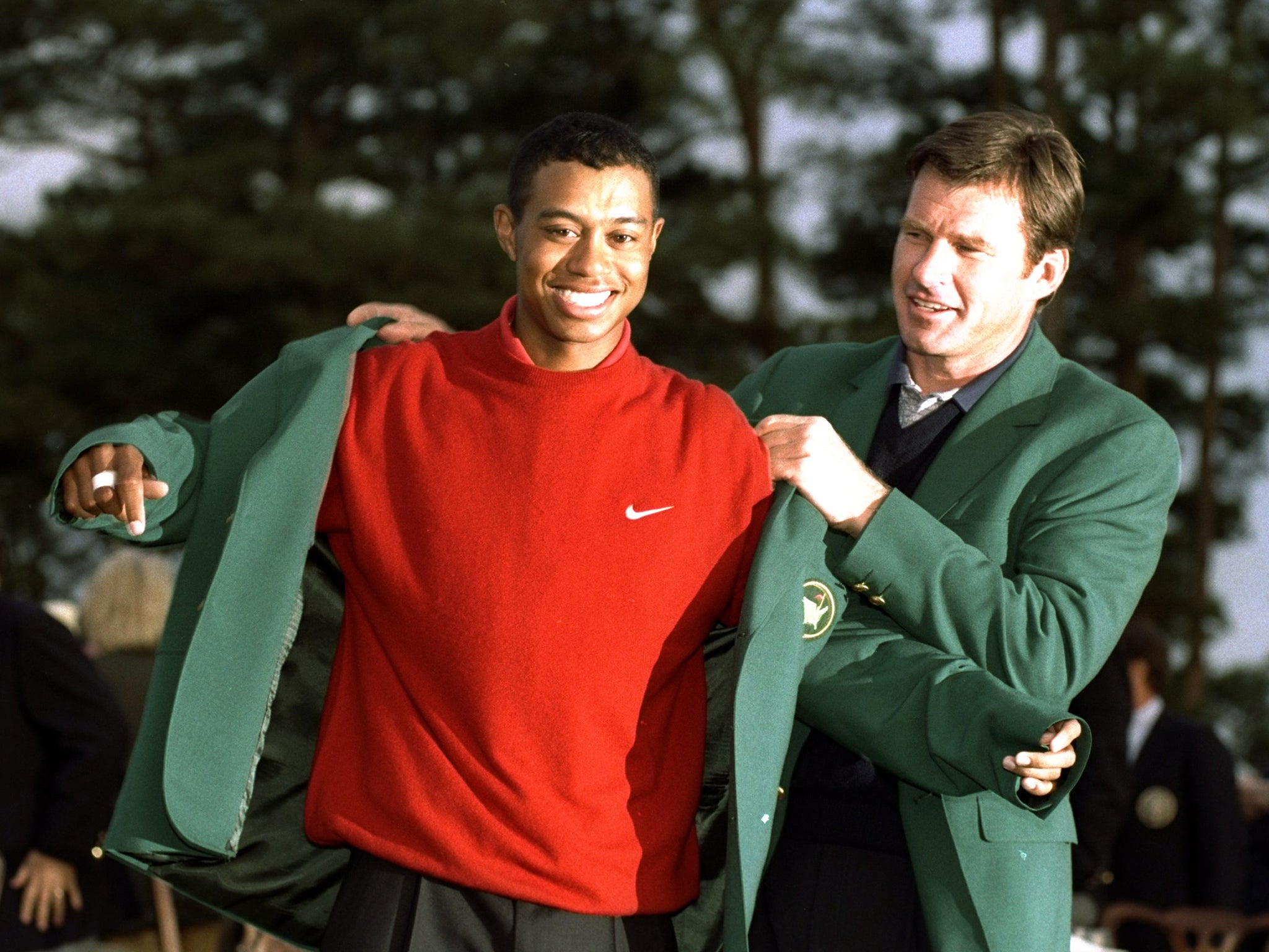 Tiger Woods receives his green jacket after winning the Masters tournament in 1997