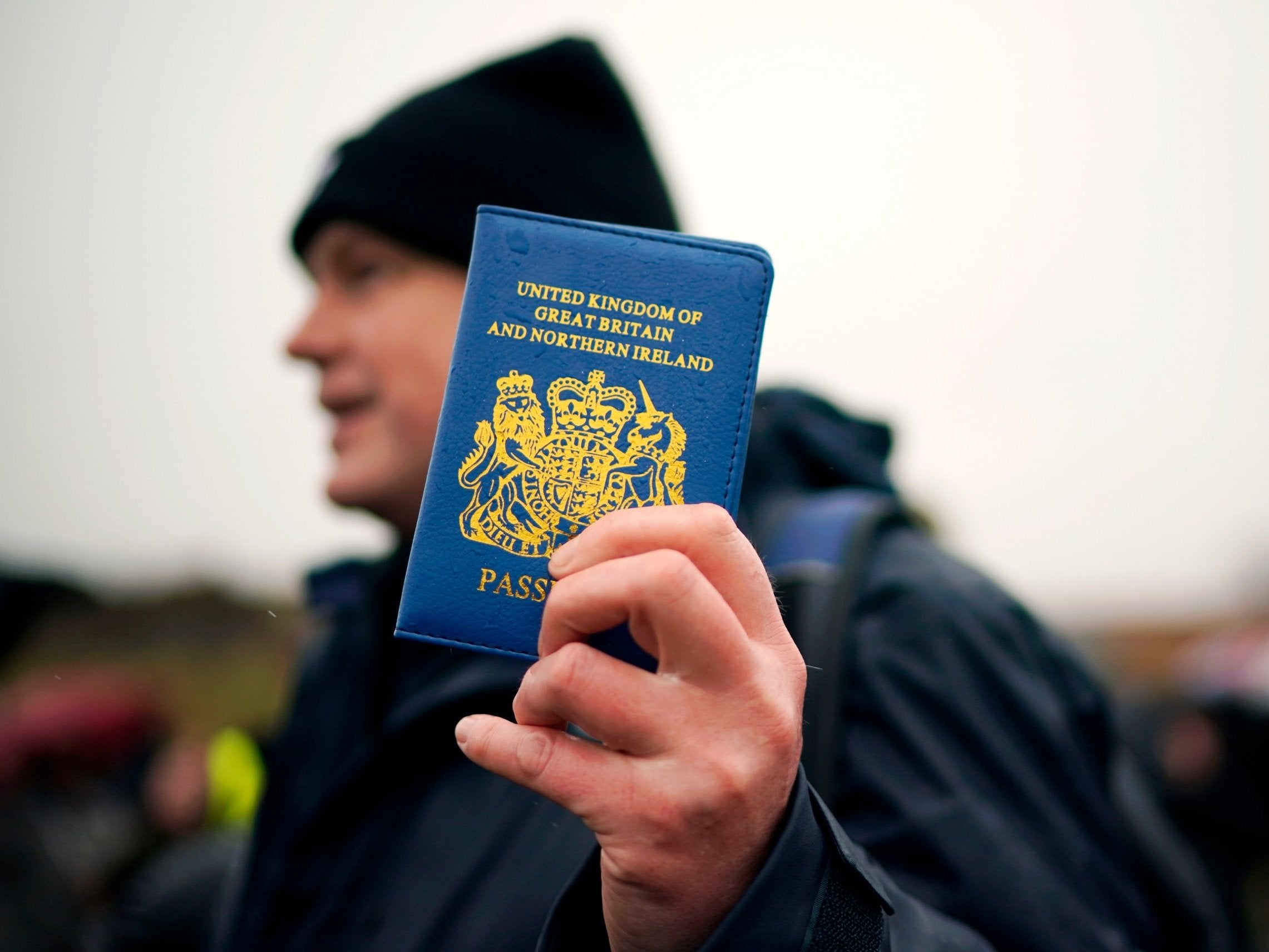 A man holds up a blue UK passport in Grangetown, Sunderland, at the beginning of the March to Leave walk on 16 March (Getty)