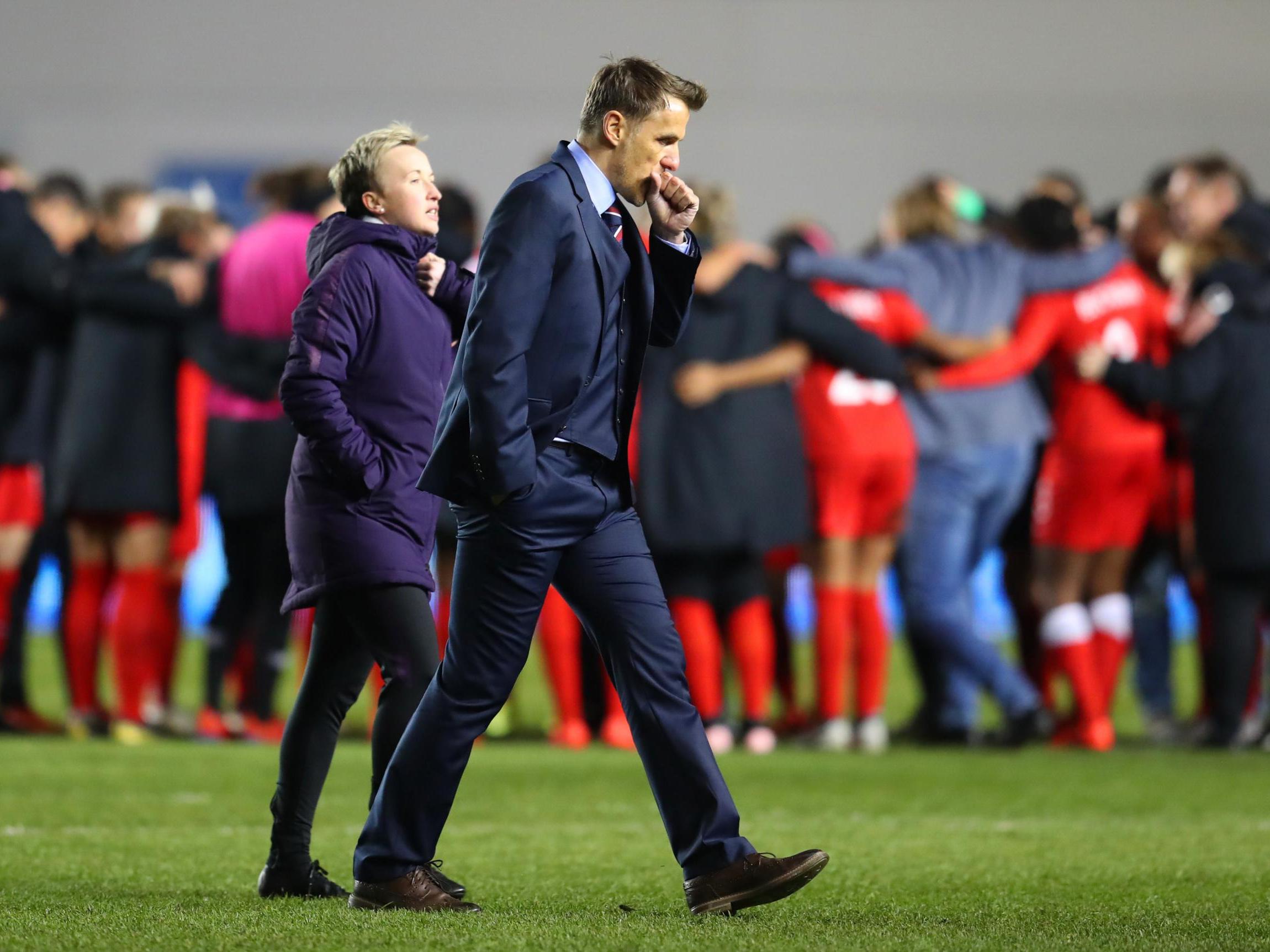 Phil Neville and Bev Priestman look on after defeat in east Manchester
