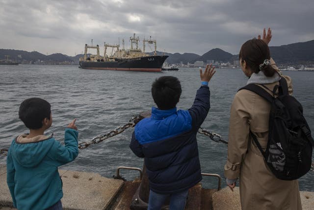 A family member waves at the Nisshin Maru crew as it returns to Shimonoseki on 31 March, 2019