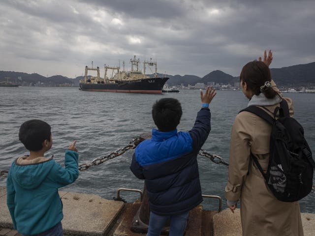 A family member waves at the Nisshin Maru crew as it returns to Shimonoseki on 31 March, 2019