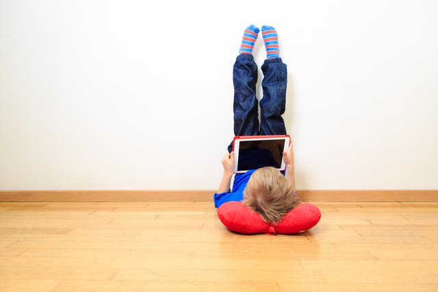 little boy looking at touch pad at home, early learning