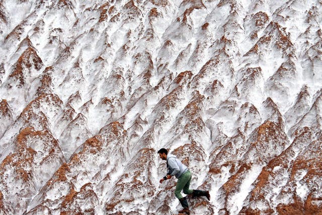 A photographer clambers along mounds of potassium waste from the local salt mine in the town of Soligorsk, some 140 km south from Minsk, on September 10, 2014