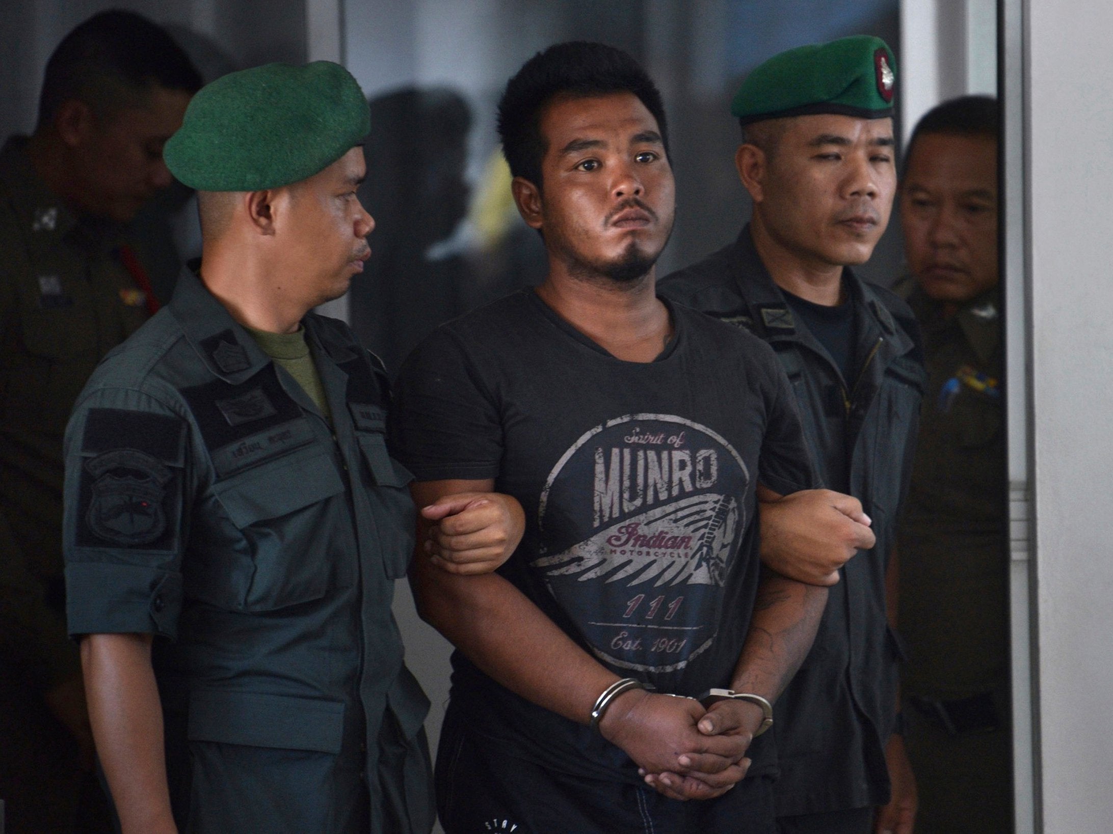 Thai suspect Ronnakorn Romruen, 23 years old, is escorted by police as he arrives at the Koh Si Chang police station in Chonburi province, Thailand