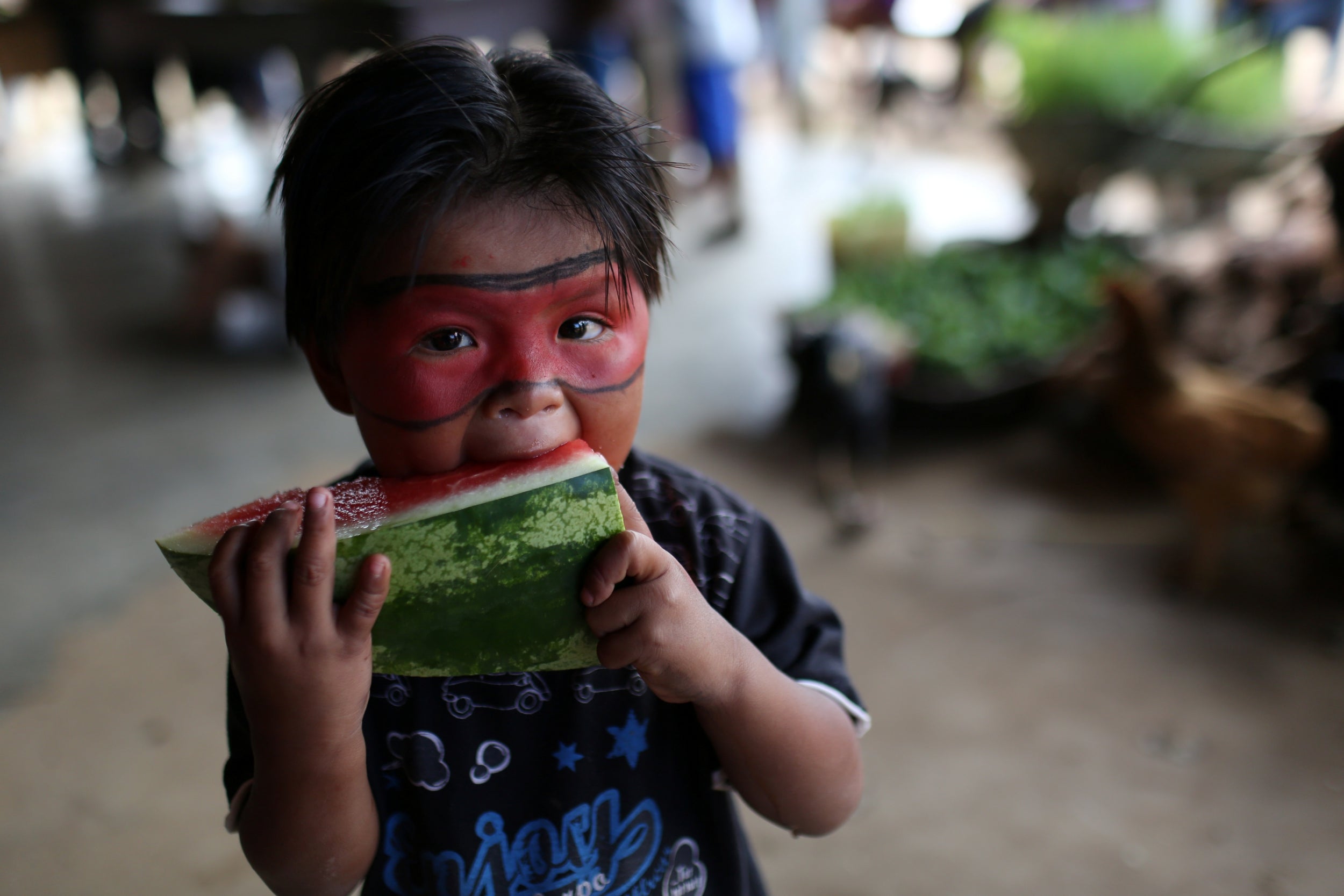A child from an indigenous tribe eats a watermelon