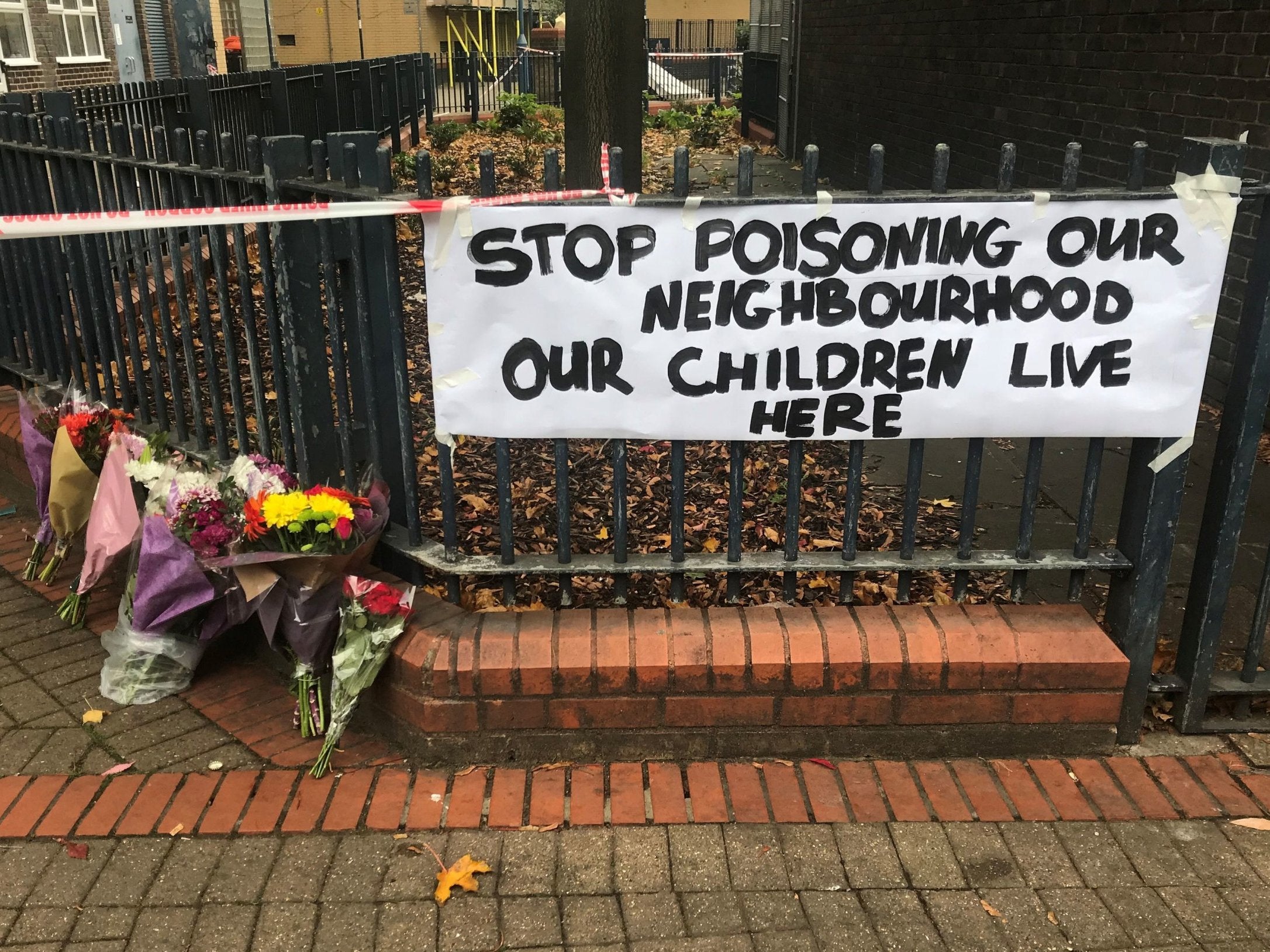 Floral tributes and sign left near Battersea flats following the death of Ian Tomlin