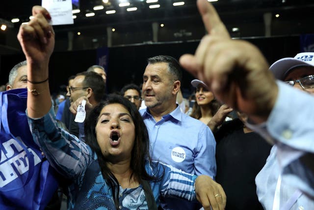 Supporters of Israeli Prime Minister Benjamin Netanyahu's Likud party react to exit polls, some of which have given him victory.