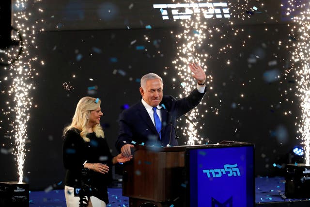 Confetti falls as Israeli Prime Minister Benjamin Netanyahu and his wife Sara stand on stage after he declared victory in the Israeli elections