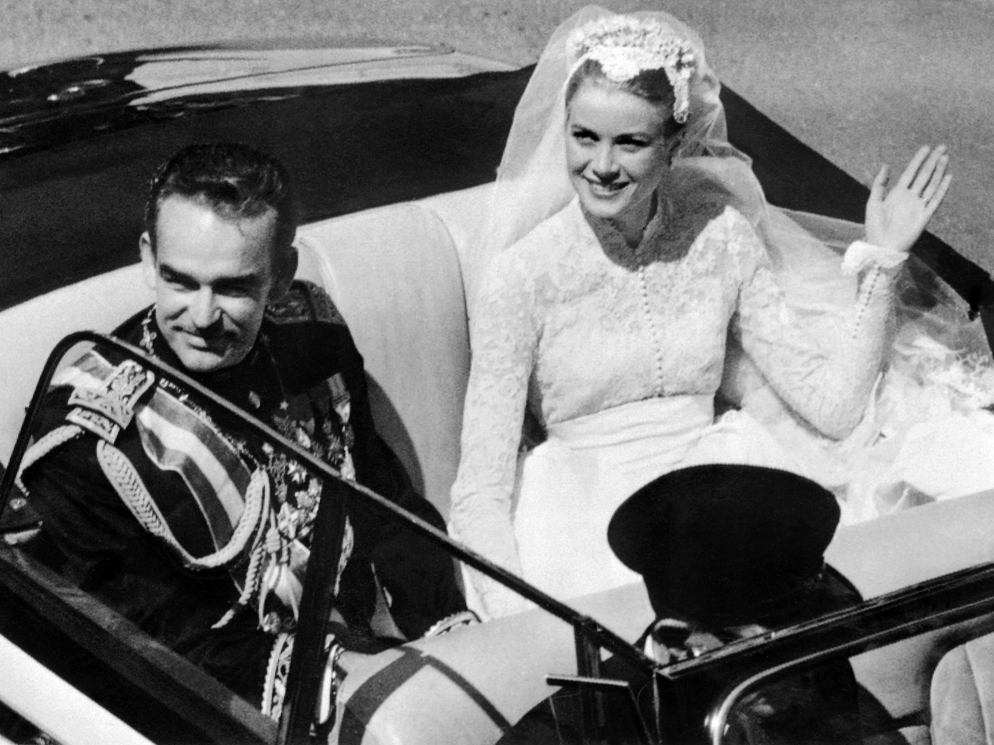 Grace Kelly and Prince Rainier III wave to the crowds as they leave their wedding ceremony in 1956