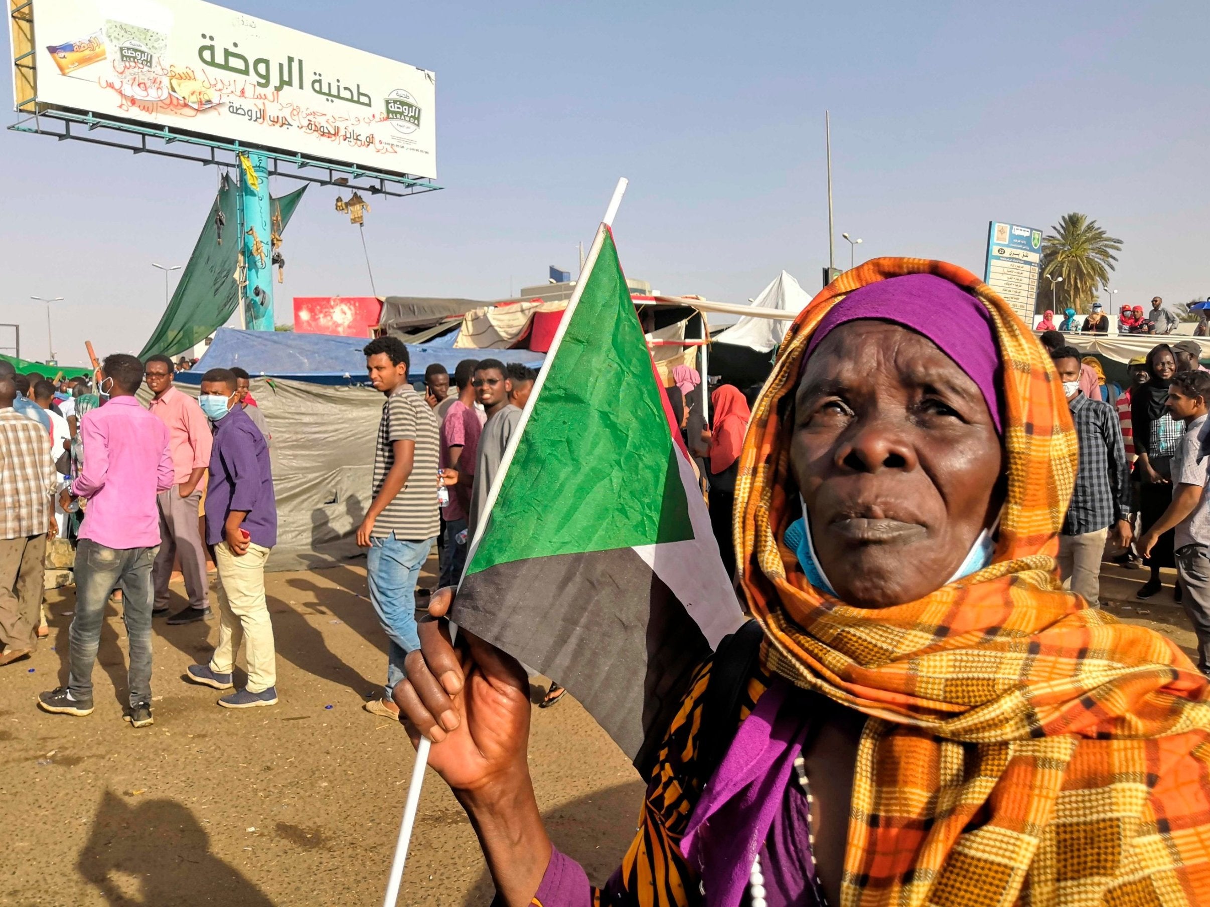 A Sudanese woman holds a national flag during a demonstration in front of the military headquarters in the capital Khartoum on Tuesday (AFP/Getty)
