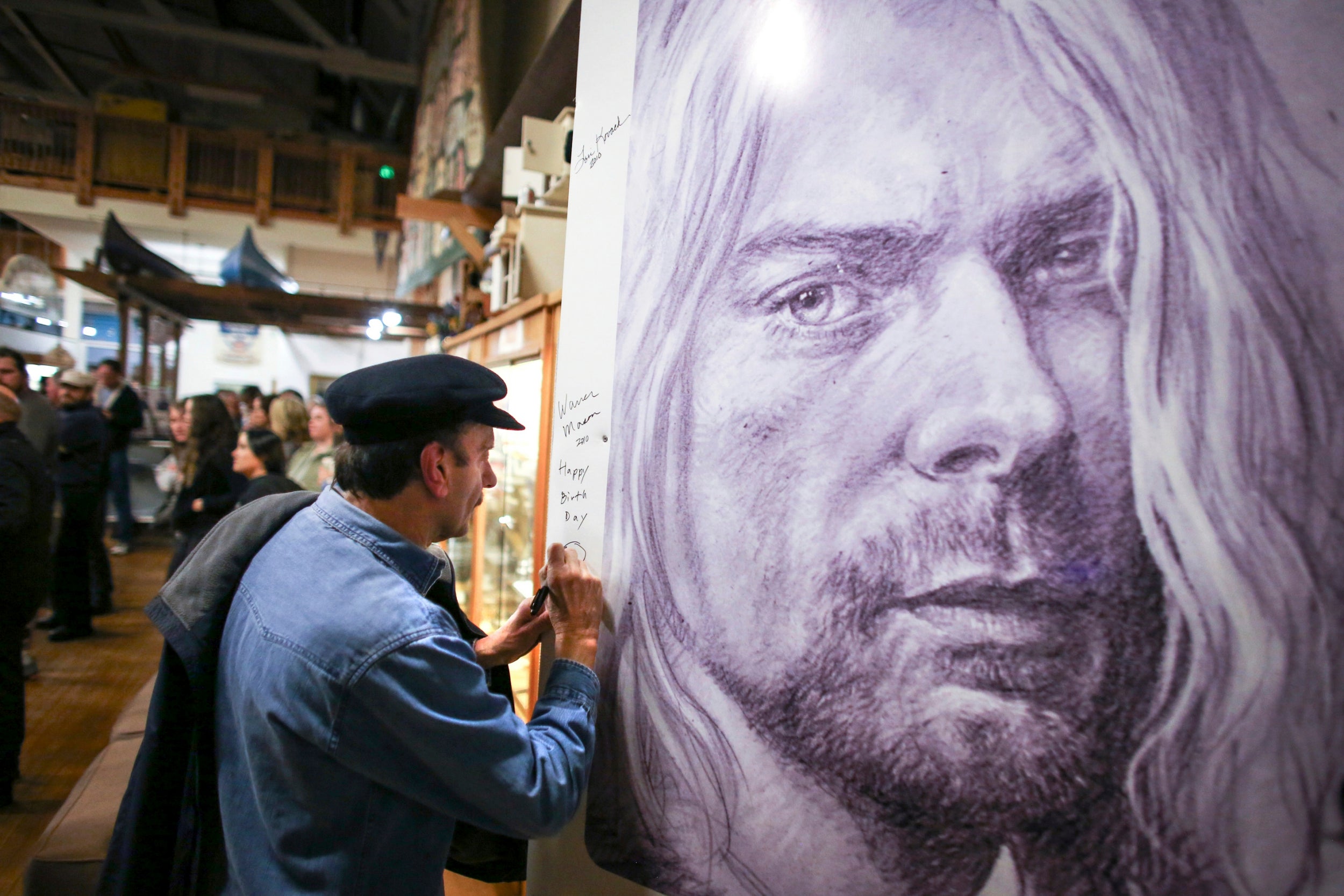 Cobain’s first guitar teacher signs a mural of the Nirvana man in Aberdeen, Washington, in 2014