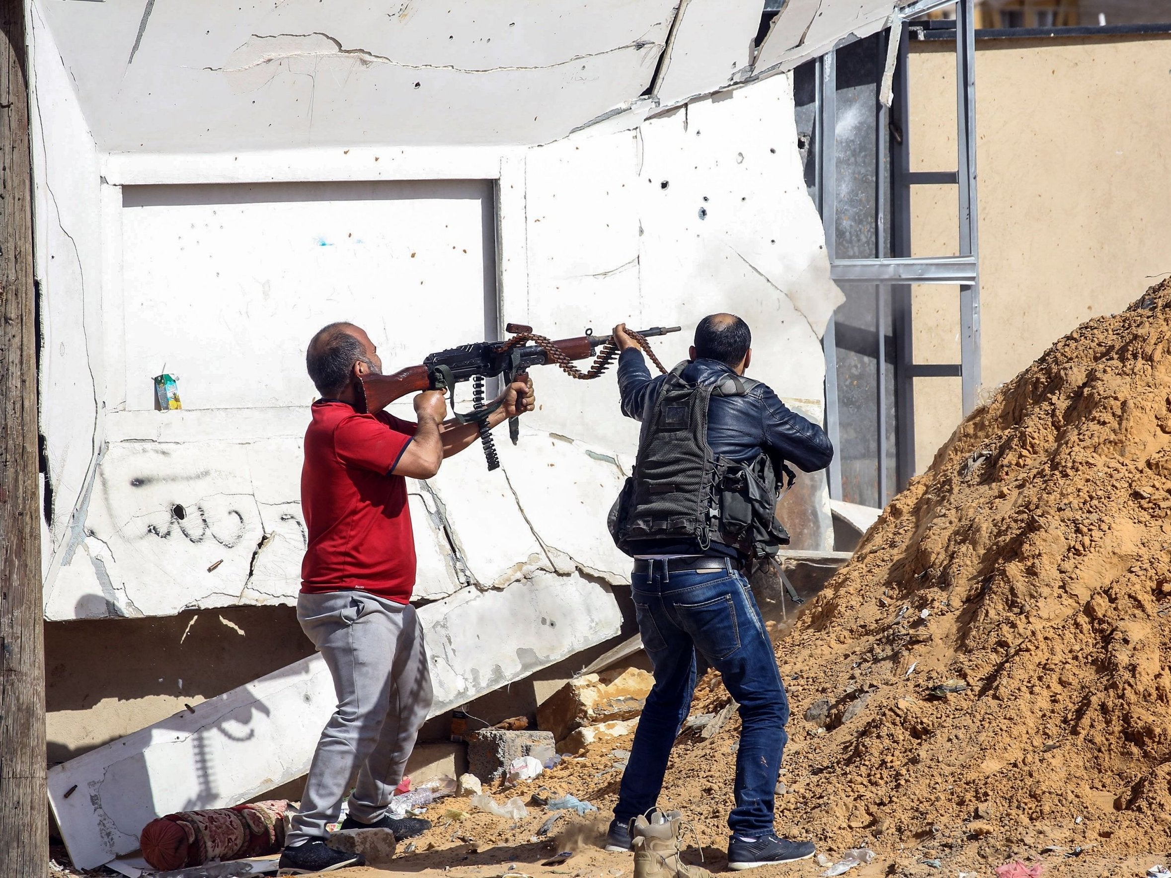 A Libyan fighter loyal to the government fires a machine gun south of Tripoli