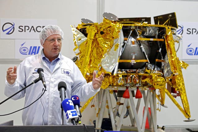 Israeli Aerospace Industries director of Space division Opher Doron speaks in front a a spacecraft weighing some 585 kilogrammes (1,300 pounds) during a presentation by Israeli nonprofit SpaceIL and Israeli state-owned Aerospace Industries