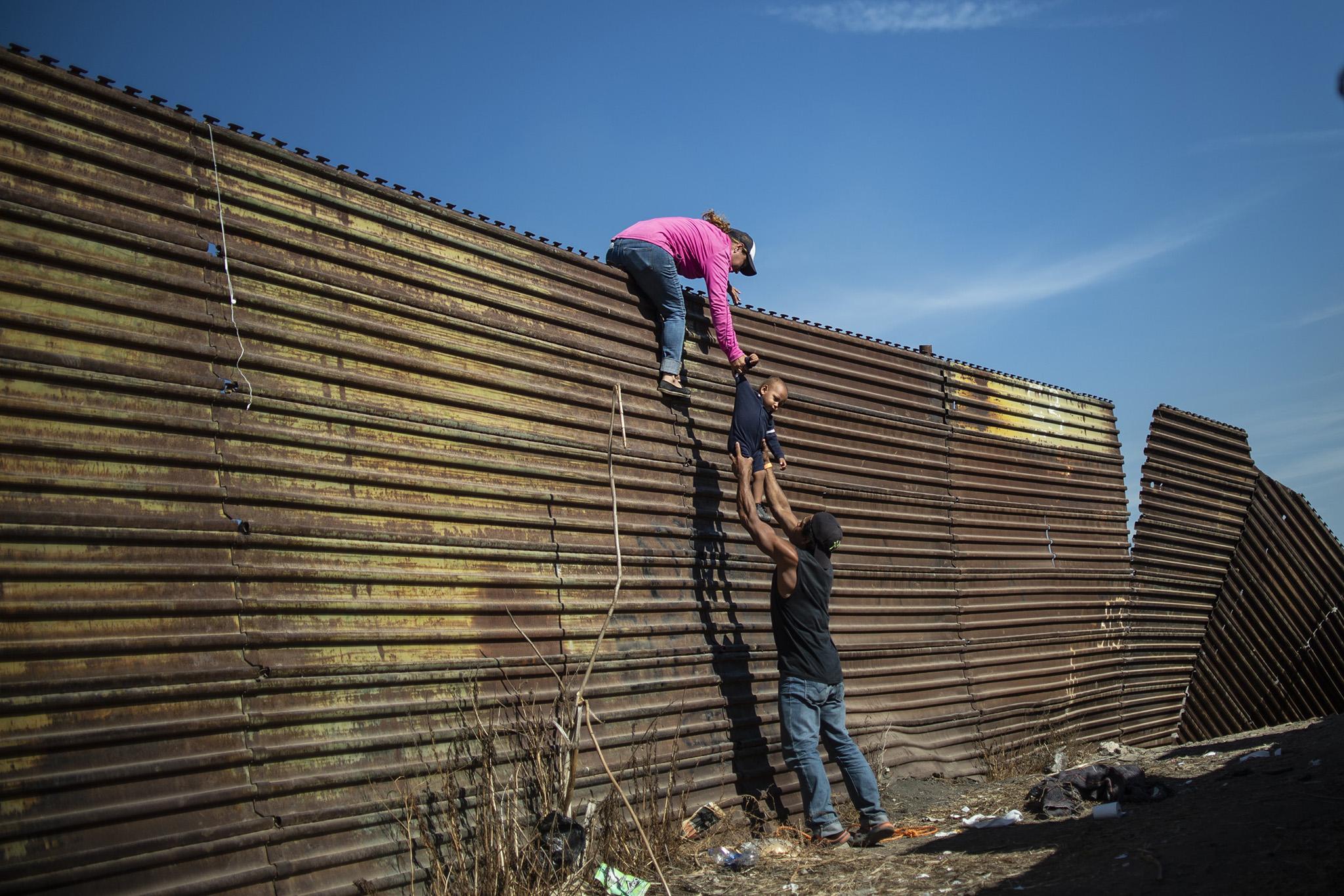 Spot news photo runner-up: Climbing the border fence