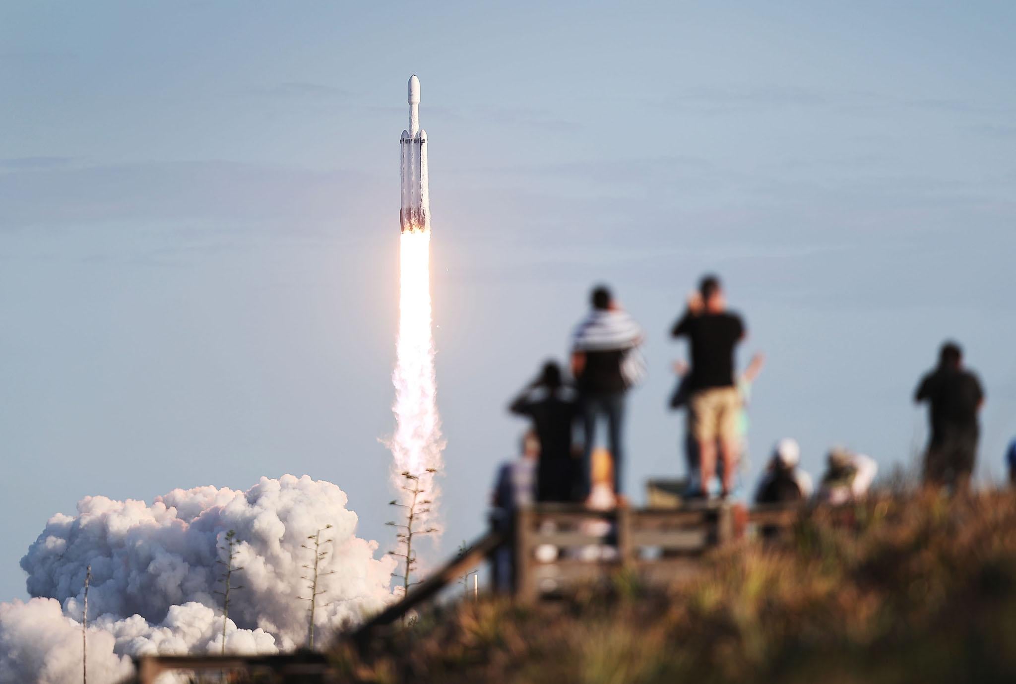 People watch as the SpaceX Falcon Heavy rocket lifts off from launch pad 39A at NASAs Kennedy Space Center on April 11, 2019 in Titusville, Florida