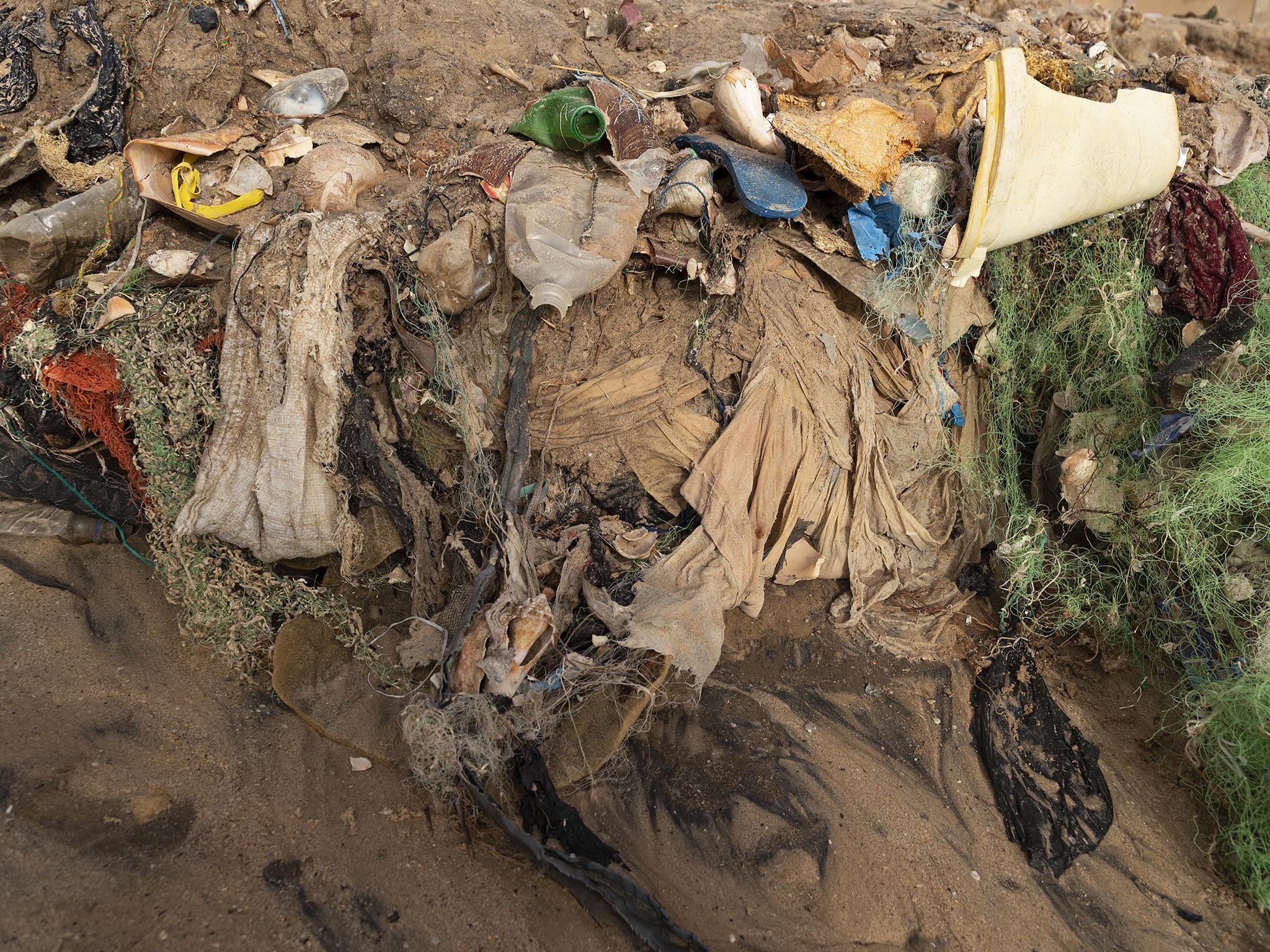 A section of beach that has been eroded away by a big storm revealing layers of waste in the beach sand in the fishing village Yenne Todd in Senegal, 24 February 2019. Senegal is choking on plastic waste with tens of thousands of tons of it ending up in the ocean every year. A problem that is not only threatening the coastal population but also the economy. Due to a lack of comprehensive municipal waste management mechanisms communities have engaged in their own clean ups in some villages. Environmentalists urge a change of policy regarding the use of plastics is urgently needed by government.