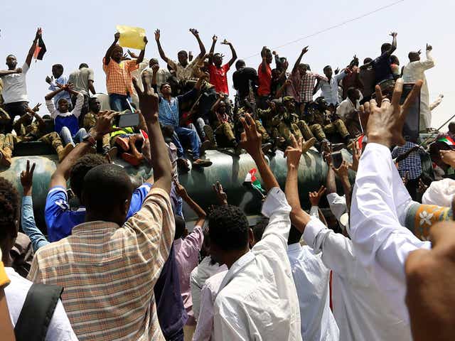 Sudanese demonstrators stand atop a military truck as they protest against the announcement of an army-led transitional council