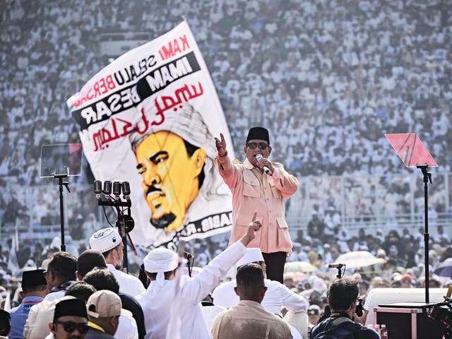 Prabowo Subianto addresses his supporters as someone waves banner of influential religious leader Habib Rizieq on 7 April