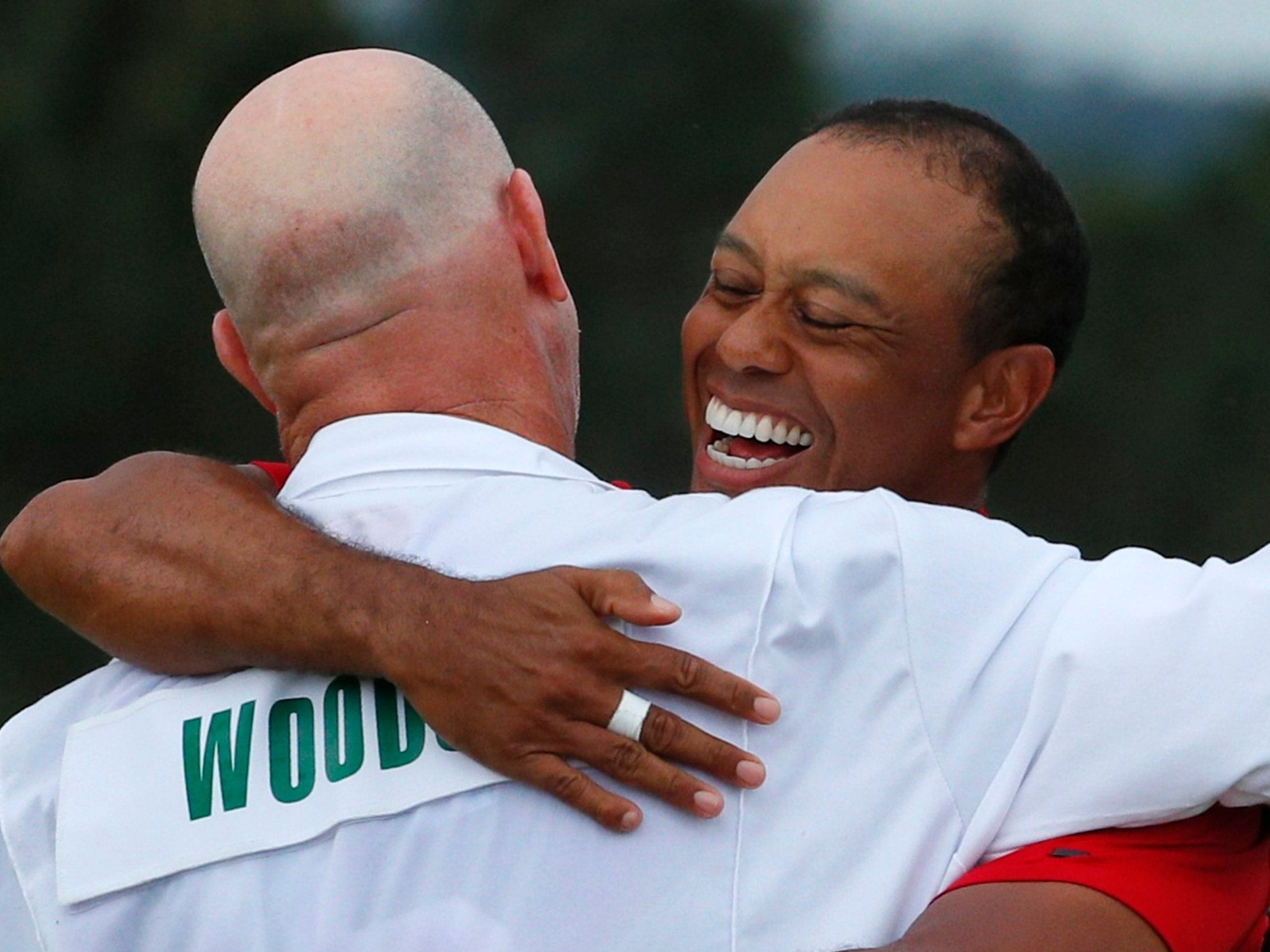 Tiger Woods embraces caddy Joe LaCava after winning the 2019 Masters