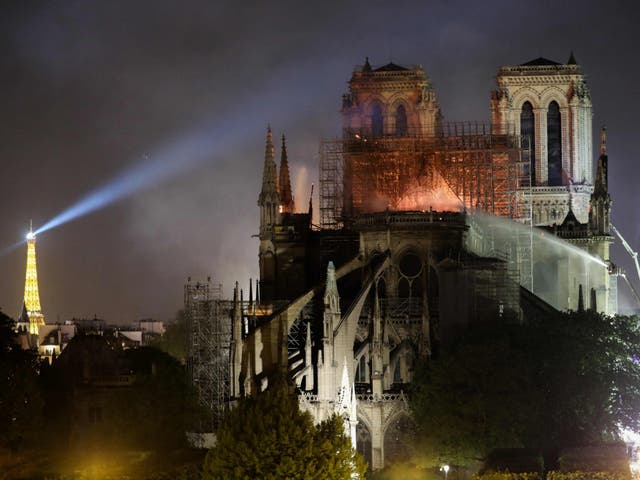 Firefighters douse flames billowing from the roof at Notre Dame