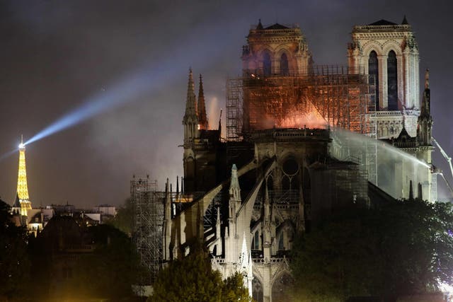 Firefighters douse flames billowing from the roof at Notre Dame