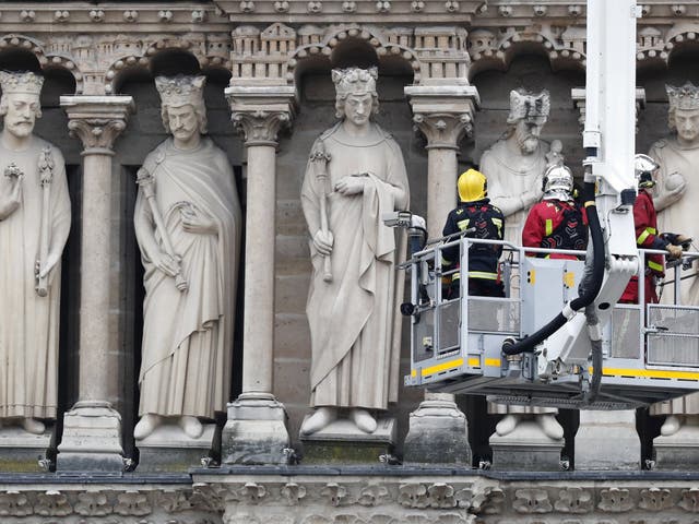 Fire fighters stand in an aerial lift after a massive fire destroyed the roof of the Notre-Dame Cathedral in Paris, France, 16 April 2019. A fire started in the late afternoon on 15 April in one of the most visited monuments of the French capital.