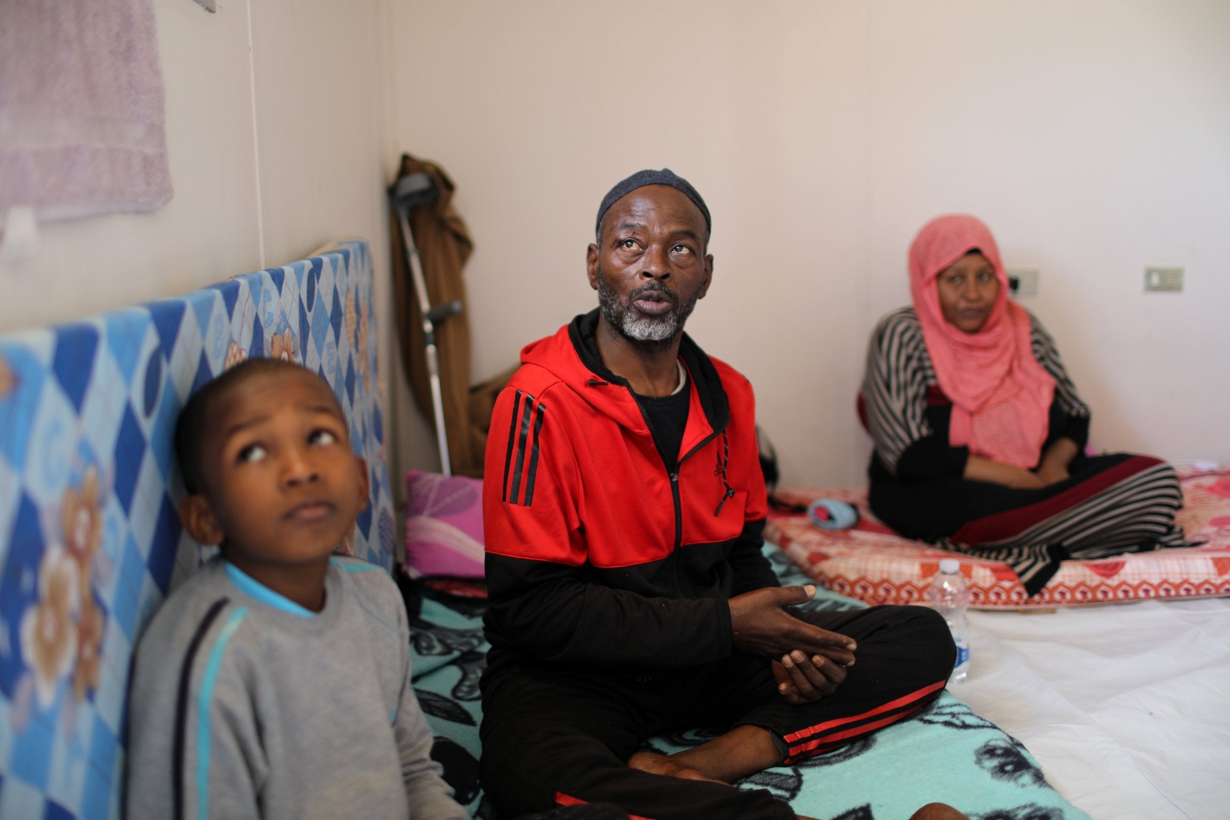 A displaced Libyan family, who fled their house because of the fighting in Tripoli, sit in an industrial complex, which is used as a shelter, in the capital