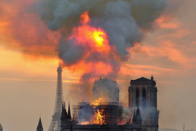 Flames and smoke rise from the inferno at its height after the roof and spire collapsed