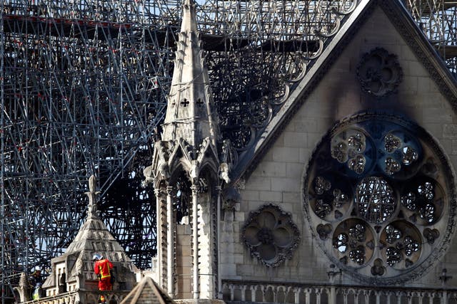 A fire fighter makes his way on a balcony of Notre Dame cathedral Wednesday