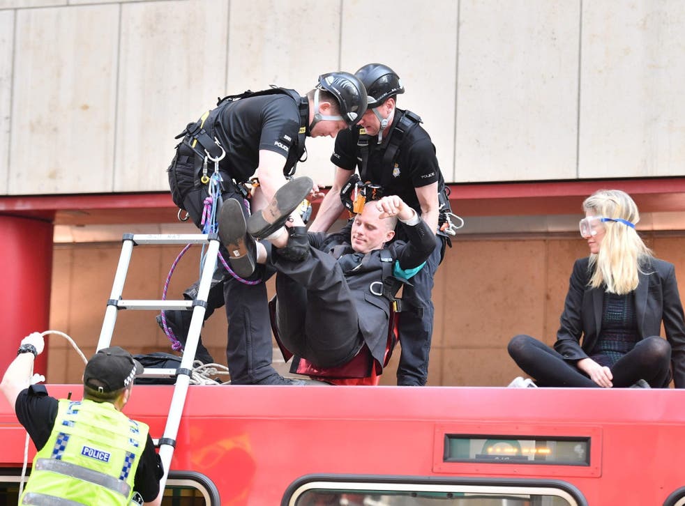 Police remove a climate change protester who had glued himself to the roof of a train