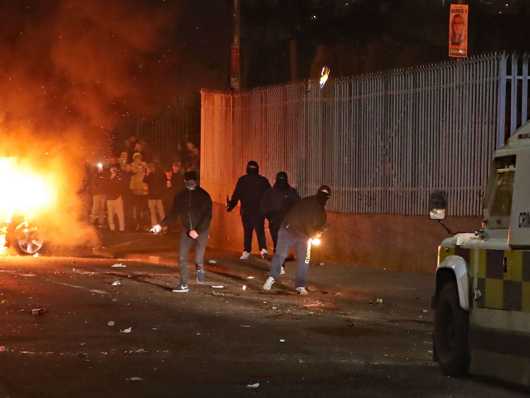 Masked men throw petrol bombs and missiles at police, shortly before Thursday’s shooting in Derry