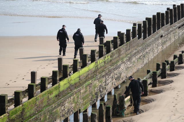 A police search team on the Aberdeen beach where they were rescued