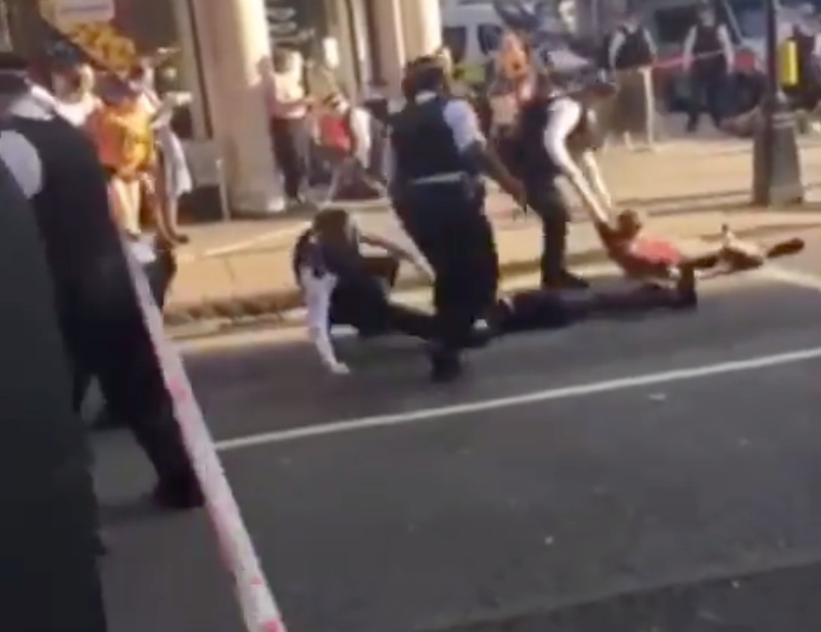 Police officers drag Extinction Rebellion protesters by their wrists
