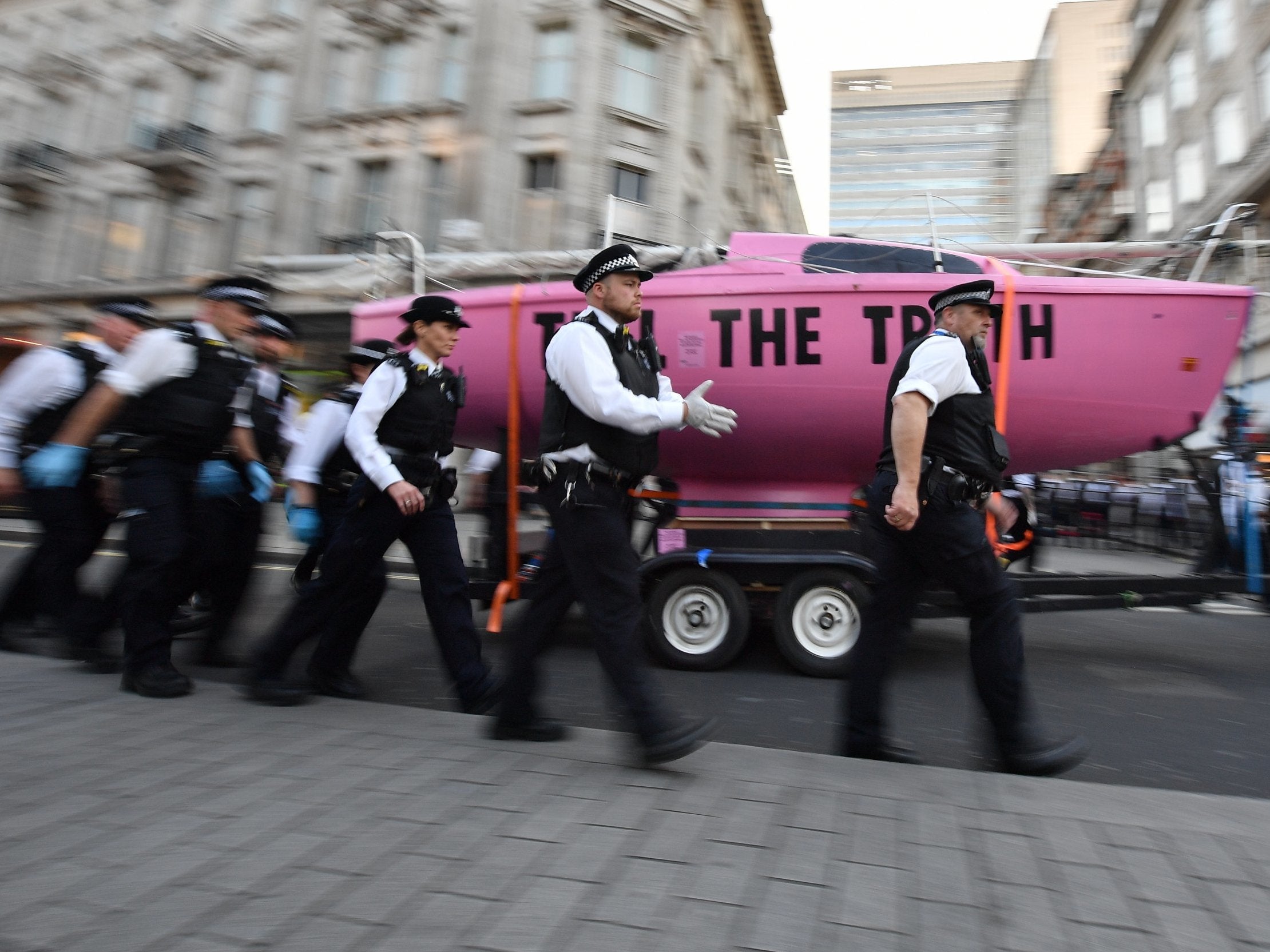 Police officers remove the pink boat at Oxford Circus