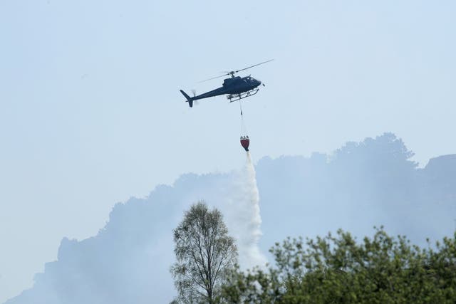 Firefighters use a helicopter to drop water as they tackle a large fire which is continuing to burn on Ilkley Moor in West Yorkshire