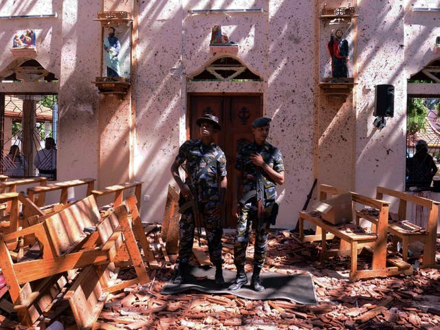 Sri Lankan military stand guard inside a church after an explosion in Negombo on 21 April