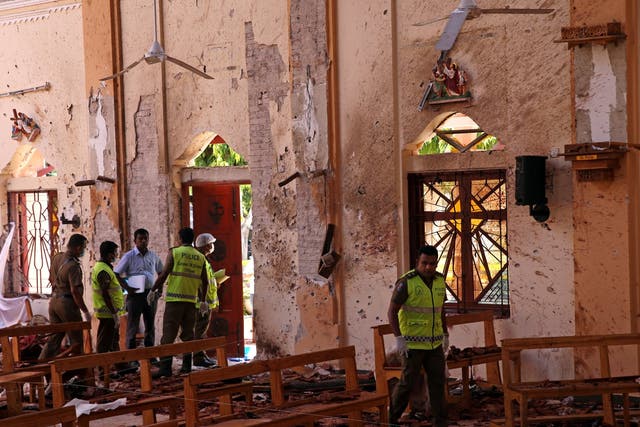 Police officers work at the scene at St Sebastian Catholic Church, after bomb blasts ripped through churches and luxury hotels on Easter, in Negambo, Sri Lanka