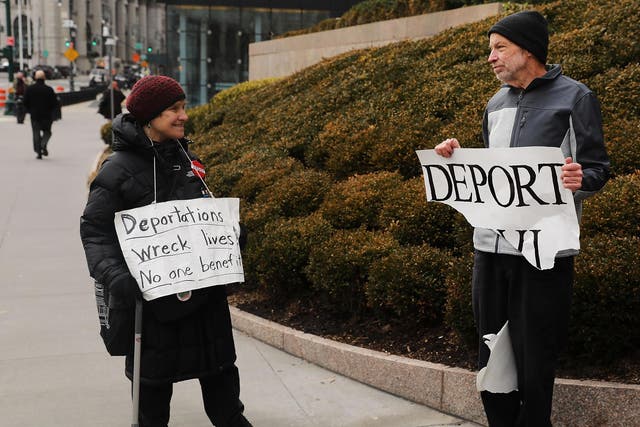 Pro Donald Trump protester (right) holds up sign calling for deportation in front of the Federal Building on 29 January 2018 New York City.