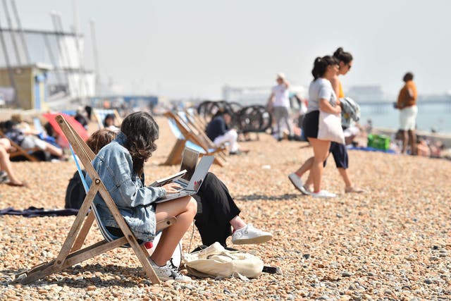 Beach goers relax by the sea in Brighton