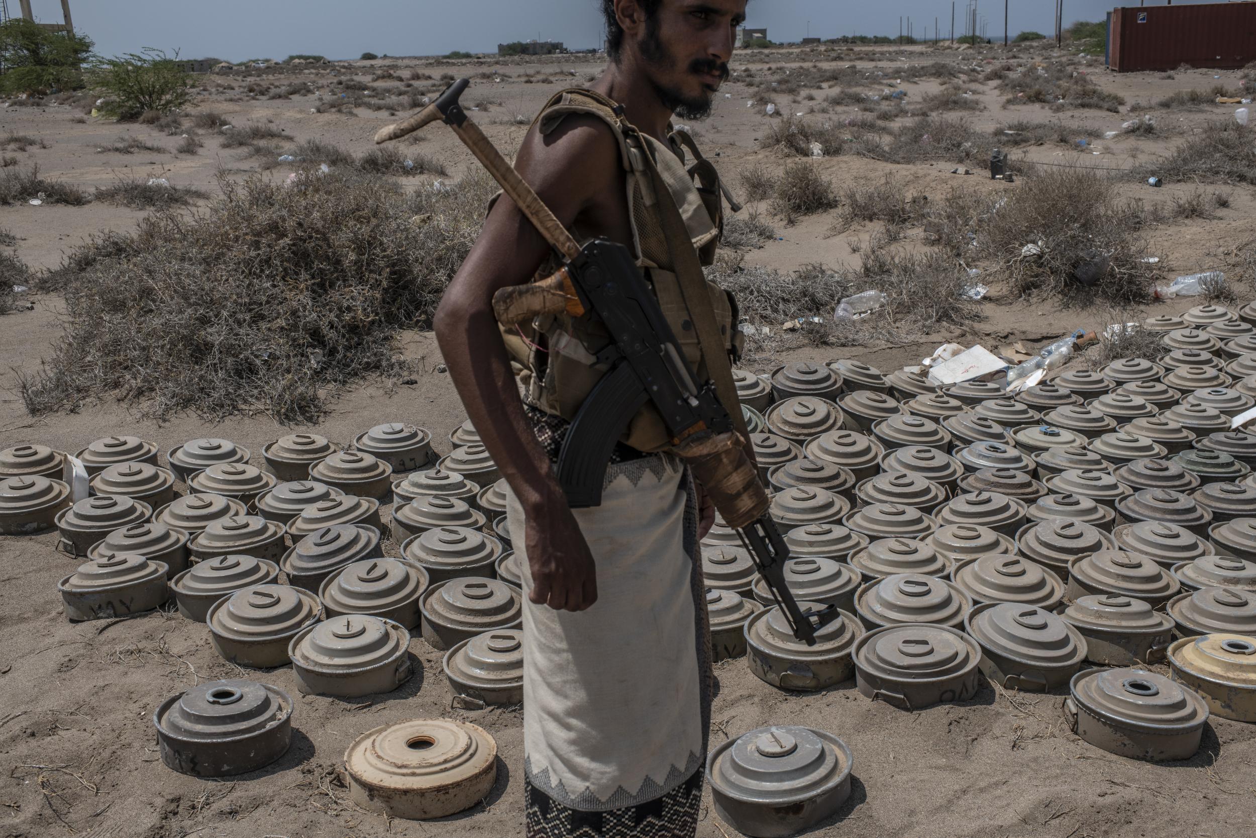 A fighter with the Tariq Salah Forces, a militia aligned with Yemen's Saudi-led coalition-backed government, shows Houthi rebel landmines the militia had recovered