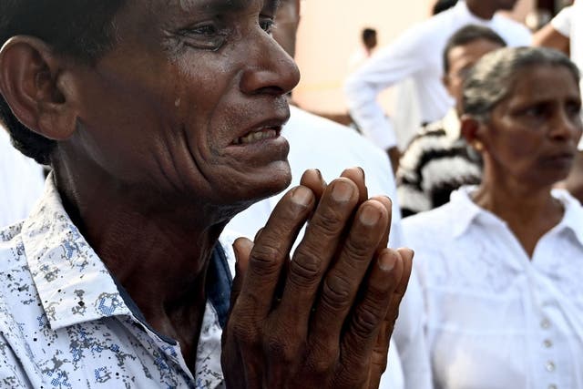 A man weeps during the service for a victim at St Sebastian’s Church yesterday
