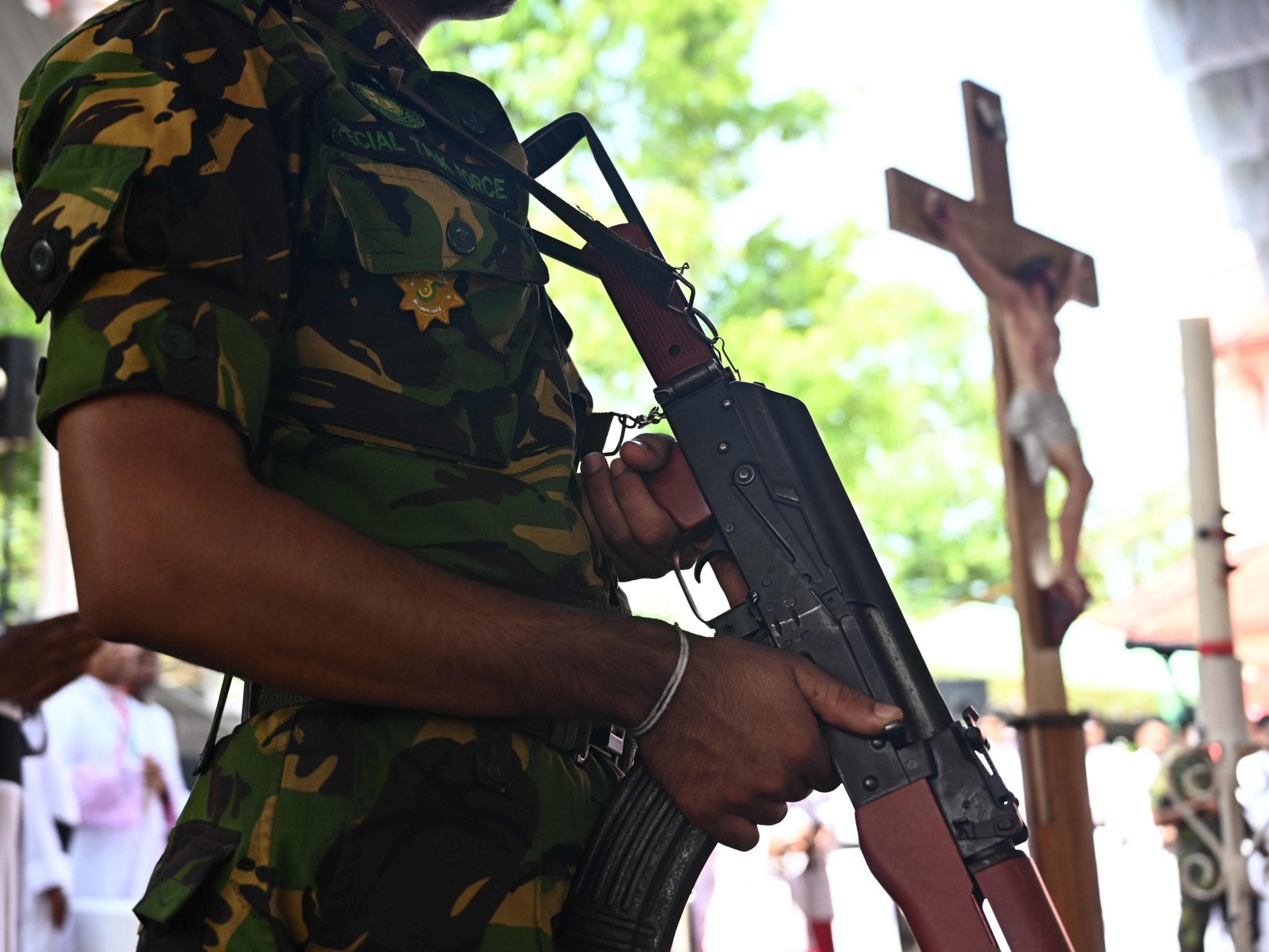 A soldier stands guard near a coffin of a bomb blast victim during a funeral service at St Sebastian's Church in Negombo