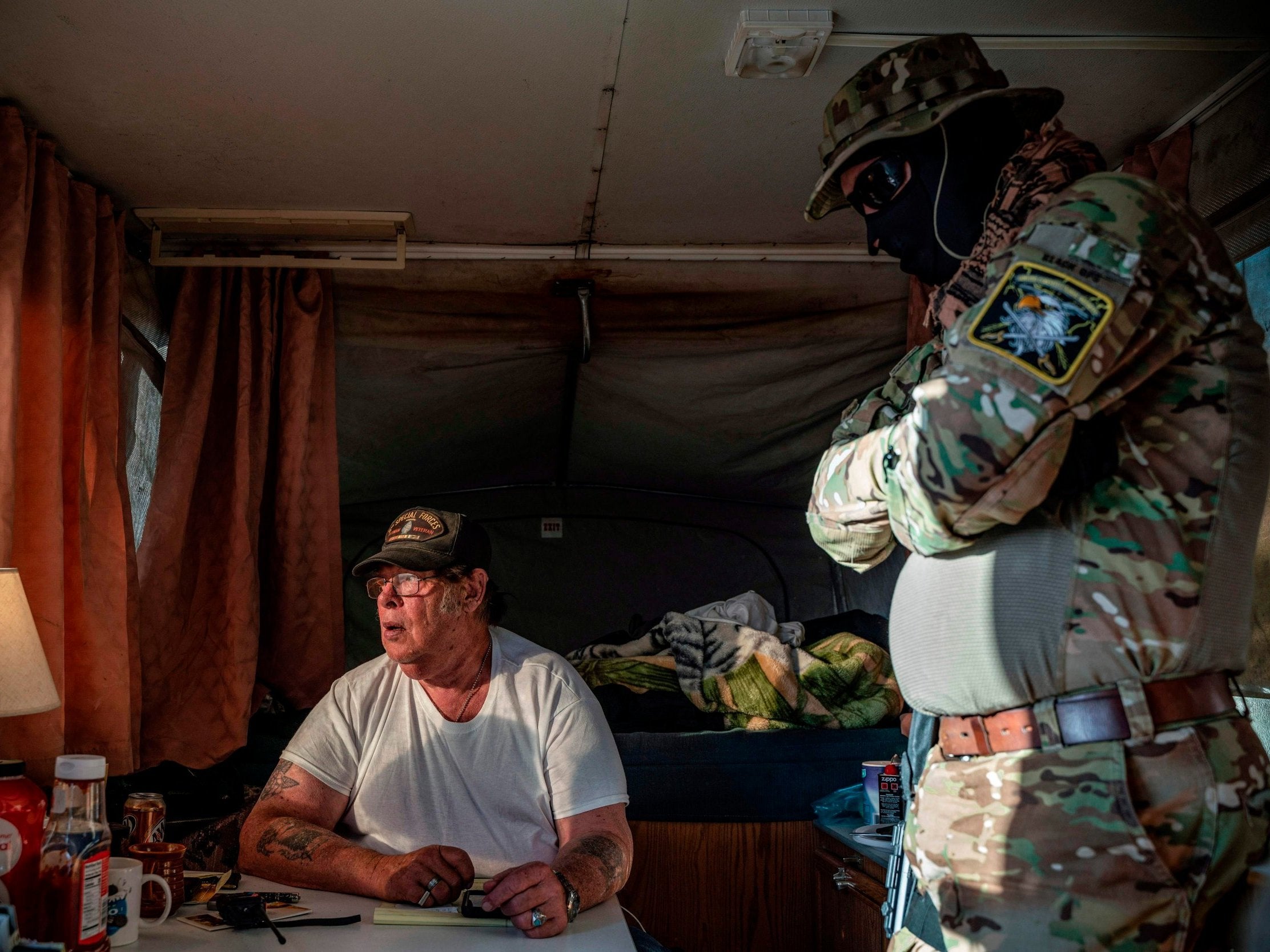 Striker, leader of the United Constitutional Patriots, speaks with Viper (R) while discussing logistics on a group chat near the US-Mexico border in Anapra, New Mexico on 20 March 2019.