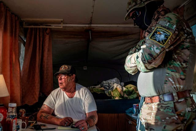 Striker, leader of the United Constitutional Patriots, speaks with Viper (R) while discussing logistics on a group chat near the US-Mexico border in Anapra, New Mexico on 20 March 2019.