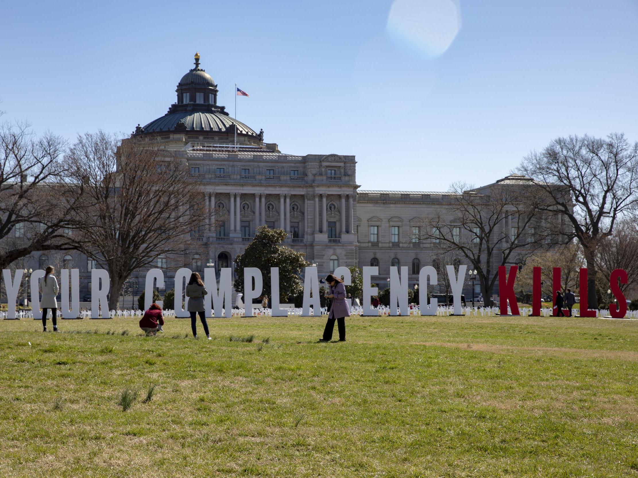 People take photos of the March For Our Lives demonstration as students place gun violence prevention art on the US Capitol grounds on 26 March 2019, Washington DC.
