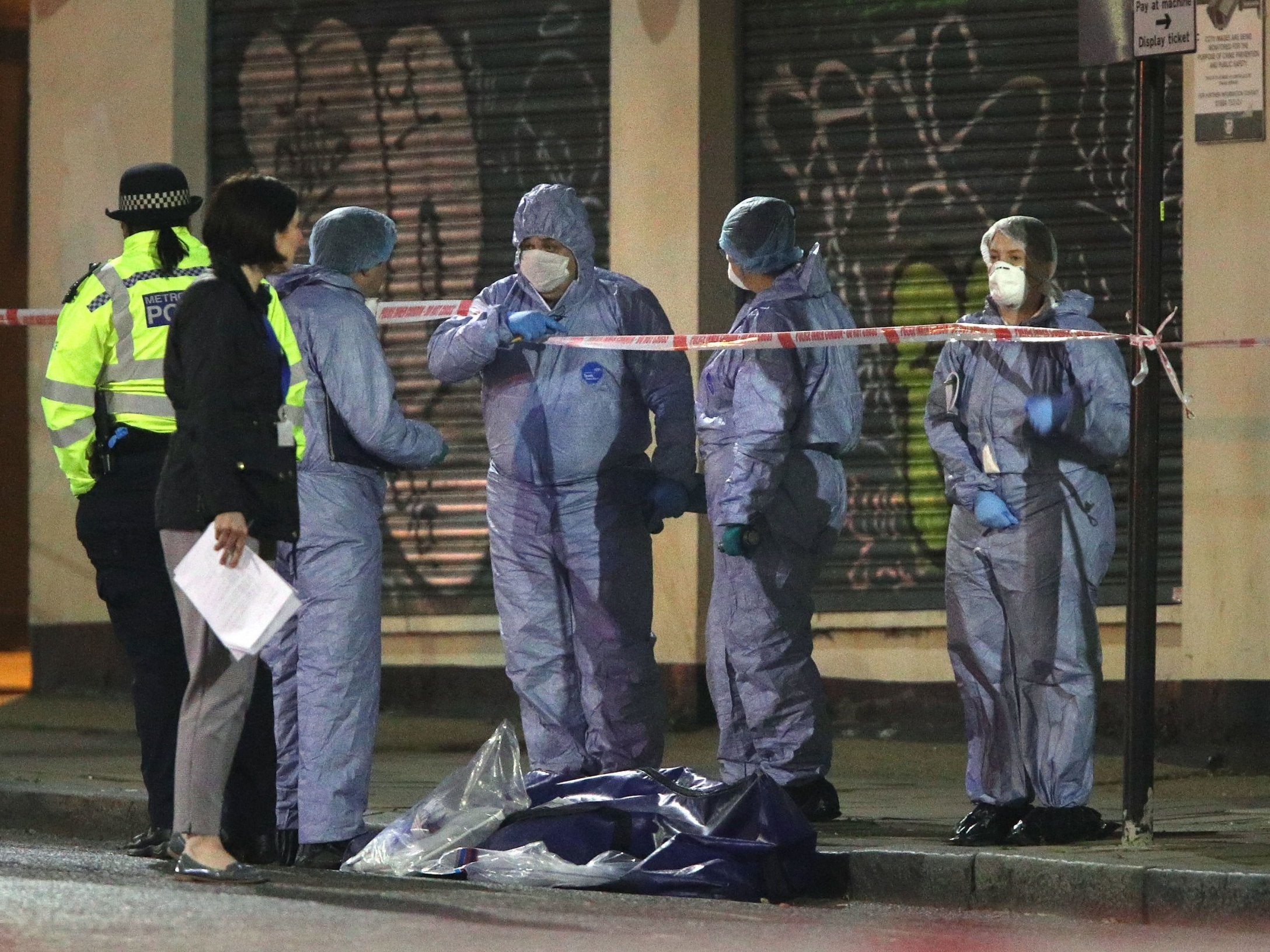 Forensic officers and police at the scene in Stoke Newington, northeast London, after a man was stabbed to death on 17 April