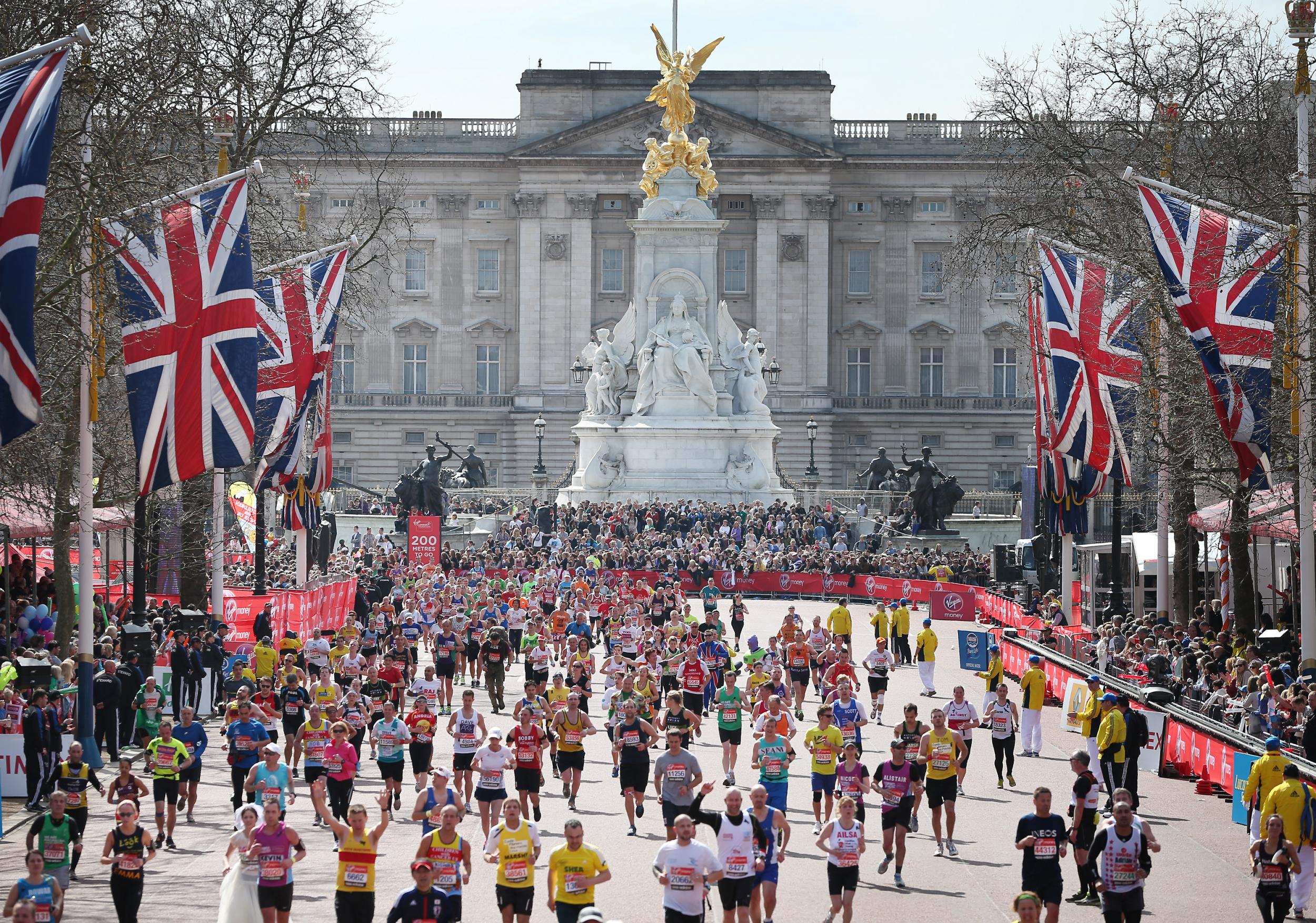 Runners in the London Marathon pass Buckingham Palace as they enter the finishing straight on April 21, 2013 in London, England.