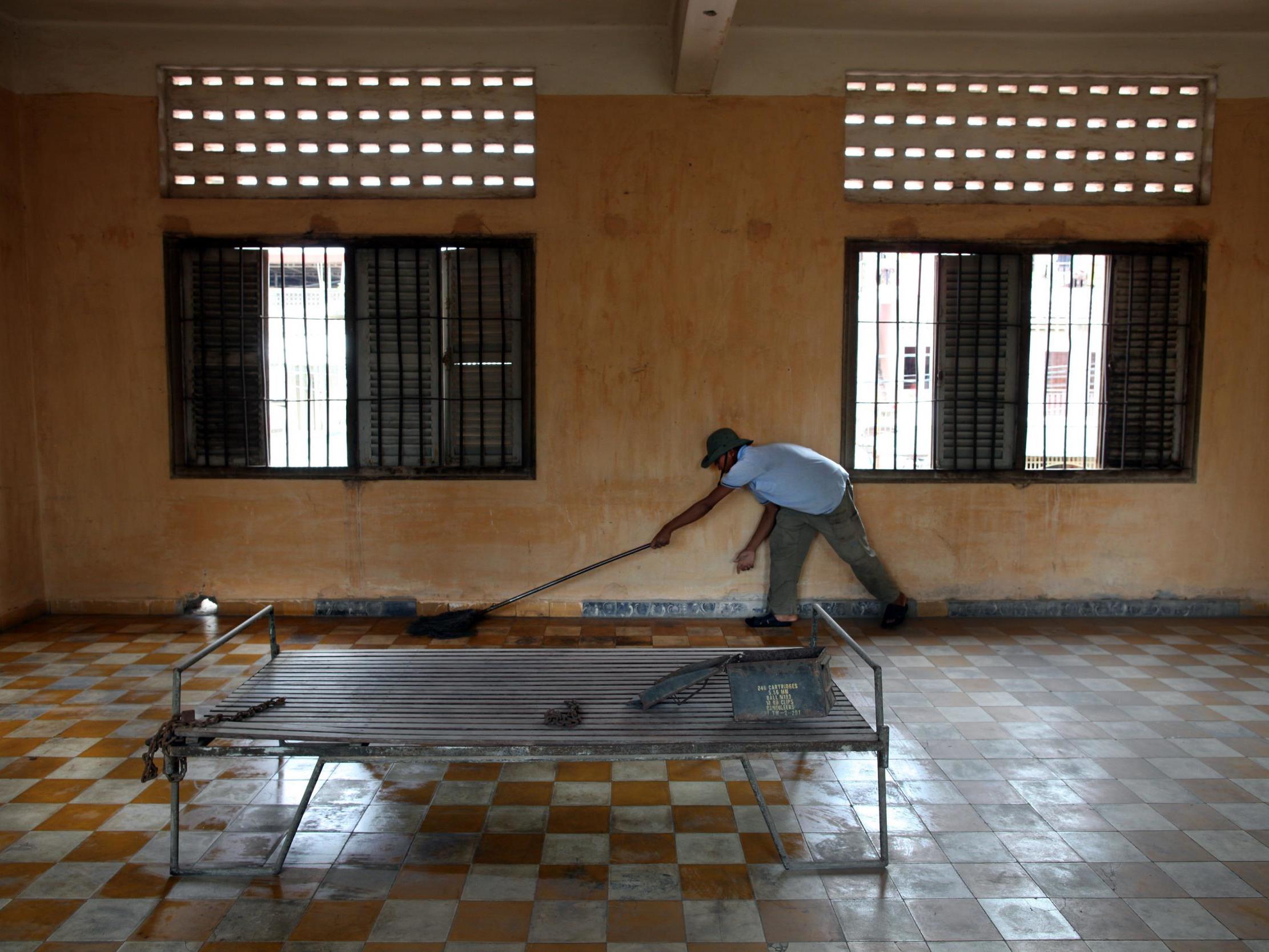 A worker cleans the floor inside the notorious S-21 prison known as Tuol Sleng, which has since been turned into a museum, where more than 15,000 people were executed during the Khmer Rouge regime